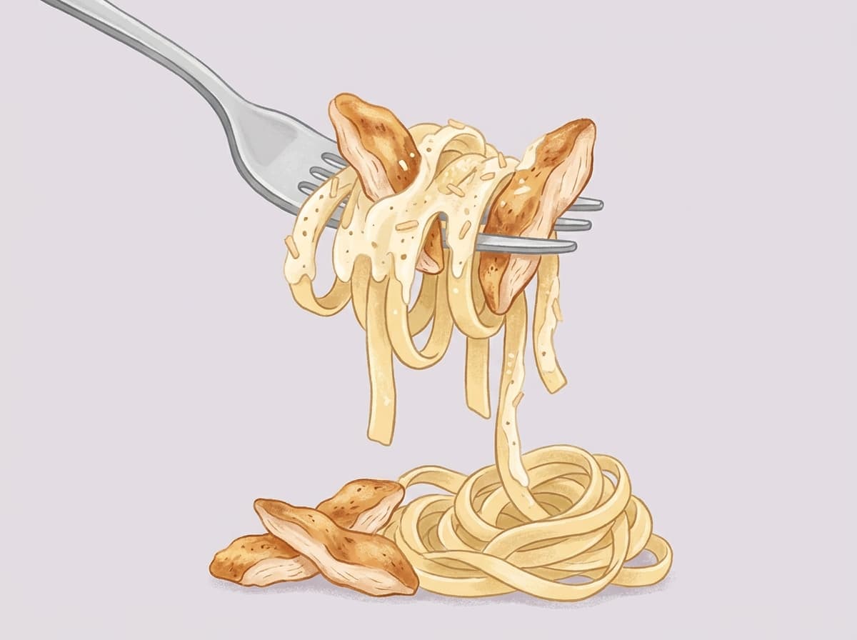 A bowl of chicken alfredo pasta topped with parmesan
